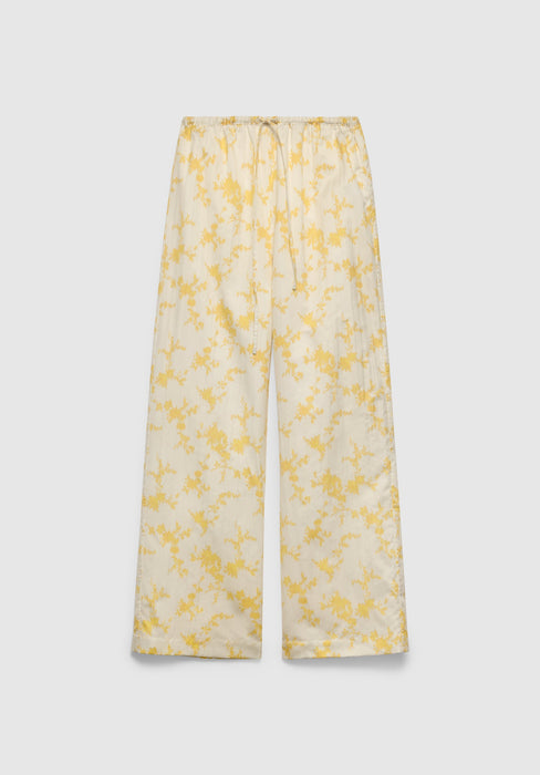 A pair of cream-colored wide-leg pants with a relaxed fit, featuring an elastic waistband with a drawstring and a delicate yellow floral print, displayed against a plain background.