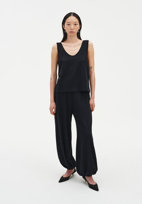 Black loose-fit trousers with a relaxed silhouette, featuring a high waist and elasticated cuffs at the ankles.