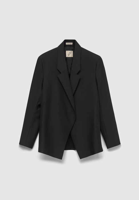 A black tailored blazer hanging against a light gray background, featuring a notched lapel, long sleeves, and a visible inner collar tag.
