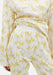 Close-up of cream trousers with a yellow abstract floral print, featuring a high elasticated waistband and soft draping fabric, paired with a matching long-sleeve top.