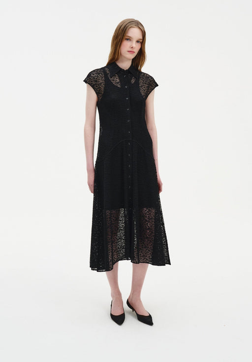Full-length front view of a woman wearing a black semi-sheer lace midi dress with a collared neckline, button-down front, and cap sleeves, styled with black pointed heels in a minimal studio setting.