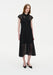 Full-length front view of a woman wearing a black semi-sheer lace midi dress with a collared neckline, button-down front, and cap sleeves, styled with black pointed heels in a minimal studio setting.